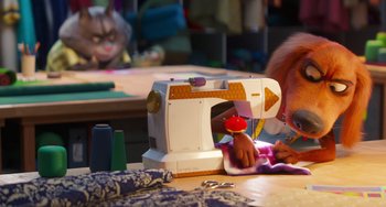 Movie still from “Sing 2” (2021), directed by Christophe Lourdelet – A person using a sewing machine on top of a wooden table; Medium shot, Over the shoulder angle