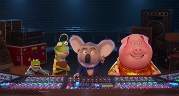 Movie still from “Sing 2” (2021), directed by Christophe Lourdelet – A group of cartoon characters sitting in front of a computer keyboard; Wide shot, High angle