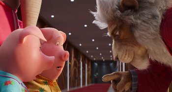 Movie still from “Sing 2” (2021), directed by Christophe Lourdelet – A pig and a lion face each other in a hallway; Medium shot, Low angle