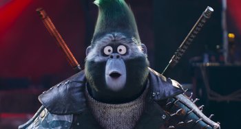 Movie still from “Sing 2” (2021), directed by Christophe Lourdelet – A monkey with a green mohawk and a green hat; Close Up shot, Low angle