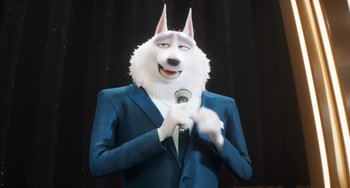 Movie still from “Sing 2” (2021), directed by Christophe Lourdelet – A man in a suit and a dog mask holding a microphone; Medium shot, Low angle