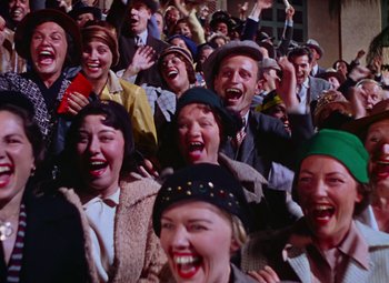 Movie still from “Singin' in the Rain” (1952), directed by Gene Kelly – A group of people that are standing in a crowd; Medium shot, High angle