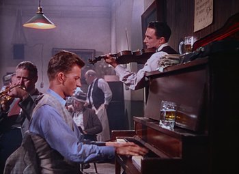 Movie still from “Singin' in the Rain” (1952), directed by Gene Kelly – A man playing piano and a man playing a violin; Medium shot, High angle