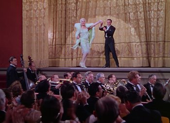 Movie still from “Singin' in the Rain” (1952), directed by Gene Kelly – A man and a woman performing on a stage with a crowd watching; Wide shot, Low angle