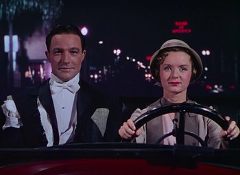 Movie still from “Singin' in the Rain” (1952), directed by Gene Kelly – A man and a woman sitting in the drivers seat of a car; Medium shot, Low angle