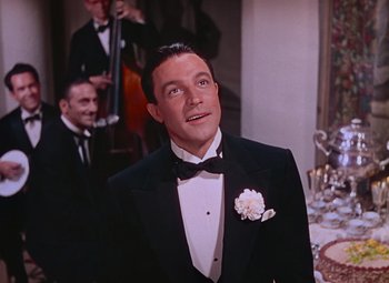Movie still from “Singin' in the Rain” (1952), directed by Gene Kelly – A person wearing a suit and a bow tie; Medium shot, Low angle