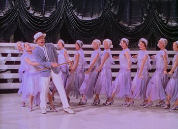 Movie still from “Singin' in the Rain” (1952), directed by Gene Kelly – A group of people in purple dresses and hats; Wide shot, High angle