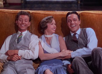 Movie still from “Singin' in the Rain” (1952), directed by Gene Kelly – A group of people sitting next to each other on a couch; Medium shot, High angle