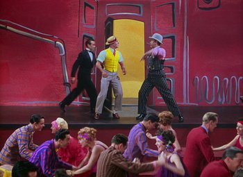 Movie still from “Singin' in the Rain” (1952), directed by Gene Kelly – A group of people standing on a stage; Wide shot, High angle