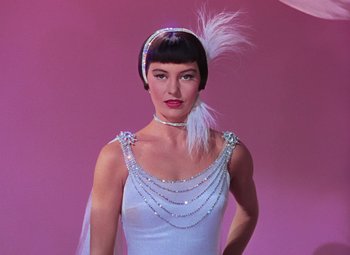 Movie still from “Singin' in the Rain” (1952), directed by Gene Kelly – A woman in a white dress with a white feather in her hair; Close Up shot, Low angle
