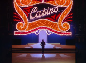 Movie still from “Singin' in the Rain” (1952), directed by Gene Kelly – A man standing in front of a casino sign; Extreme Wide shot, Low angle