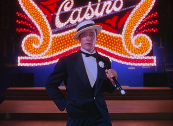 Movie still from “Singin' in the Rain” (1952), directed by Gene Kelly – A man in a suit and hat holding a cane; Medium shot, Low angle