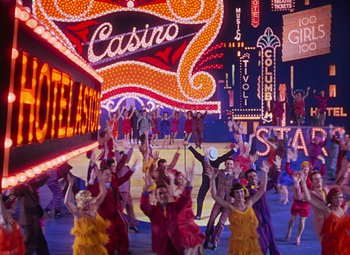 Movie still from “Singin' in the Rain” (1952), directed by Gene Kelly – A group of people dancing in front of a neon sign; Extreme Wide shot, High angle