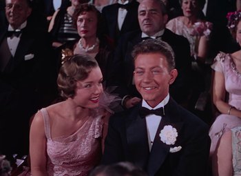 Movie still from “Singin' in the Rain” (1952), directed by Gene Kelly – A man and a woman in formal wear at an event; Medium shot, High angle