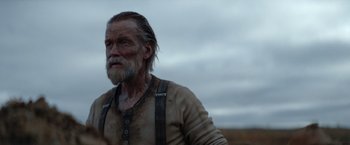 Movie still from “Sisu” (2022), directed by Jalmari Helander – An old man with long hair and a long beard; Close Up shot, Low angle