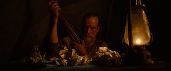 Movie still from “Sisu” (2022), directed by Jalmari Helander – An old man holding a gun in his hand; Close Up shot, Low angle