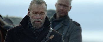 Movie still from “Sisu” (2022), directed by Jalmari Helander – A man with a brush in his mouth and another man with a brush in his other hand; Close Up shot, Over the shoulder angle