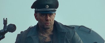 Movie still from “Sisu” (2022), directed by Jalmari Helander – A person wearing a hat; Close Up shot, Low angle