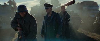 Movie still from “Sisu” (2022), directed by Jalmari Helander – A group of men standing next to each other in a field; Medium shot, Low angle