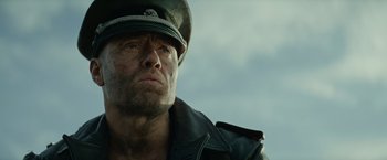 Movie still from “Sisu” (2022), directed by Jalmari Helander – A person wearing a uniform; Close Up shot, Low angle