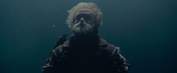 Movie still from “Sisu” (2022), directed by Jalmari Helander – An old man with a long white beard is underwater; Medium shot, Low angle
