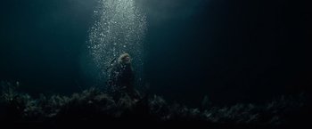 Movie still from “Sisu” (2022), directed by Jalmari Helander – A person swimming in the ocean under the water; Extreme Wide shot, Overhead angle