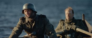Movie still from “Sisu” (2022), directed by Jalmari Helander – A man in a military uniform riding a motorcycle; Close Up shot, Over the shoulder angle