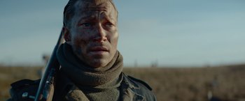 Movie still from “Sisu” (2022), directed by Jalmari Helander – A person wearing a sweater; Close Up shot, Over the shoulder angle