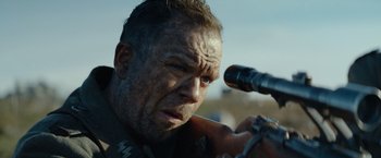 Movie still from “Sisu” (2022), directed by Jalmari Helander – A person holding a telescope; Close Up shot, Over the shoulder angle
