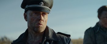 Movie still from “Sisu” (2022), directed by Jalmari Helander – A person wearing a uniform; Close Up shot, Low angle