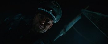 Movie still from “Sisu” (2022), directed by Jalmari Helander – A person wearing a hat; Close Up shot, Low angle