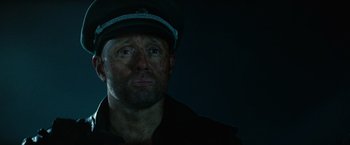 Movie still from “Sisu” (2022), directed by Jalmari Helander – A person wearing a hat; Close Up shot, Low angle