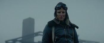 Movie still from “Sisu” (2022), directed by Jalmari Helander – A man in a leather jacket wearing goggles and an aviator hat; Close Up shot, Low angle