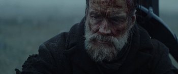 Movie still from “Sisu” (2022), directed by Jalmari Helander – An old man with a beard and a white beard; Close Up shot, Low angle