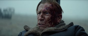 Movie still from “Sisu” (2022), directed by Jalmari Helander – An old man with blood on his face and head; Close Up shot, Low angle