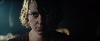Movie still from “Sisu” (2022), directed by Jalmari Helander – A person's face in the dark; Close Up shot, Over the shoulder angle