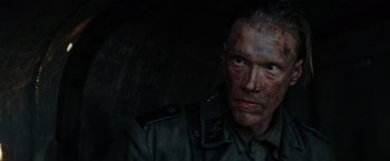 Movie still from “Sisu” (2022), directed by Jalmari Helander – A man in military uniform looking into the camera; Close Up shot, Low angle