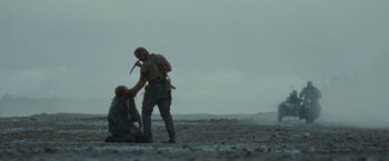 Movie still from “Sisu” (2022), directed by Jalmari Helander – Two men in the desert one of which is holding a knife and the other is holding a knife in his hand; Wide shot, Over the shoulder angle