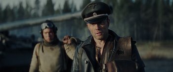 Movie still from “Sisu” (2022), directed by Jalmari Helander – A man in a leather jacket and a hat; Close Up shot, Over the shoulder angle