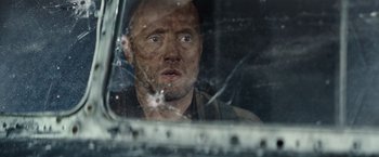 Movie still from “Sisu” (2022), directed by Jalmari Helander – A man looking out of a car window; Close Up shot, Over the shoulder angle