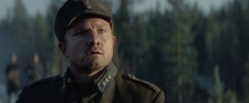 Movie still from “Sisu” (2022), directed by Jalmari Helander – A person wearing a hat; Close Up shot, Over the shoulder angle