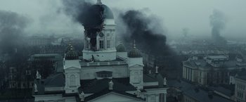 Movie still from “Sisu” (2022), directed by Jalmari Helander – A large building that has a clock on the top of it; Extreme Wide shot, Low angle