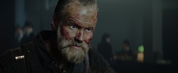 Movie still from “Sisu” (2022), directed by Jalmari Helander – A person with a beard; Close Up shot, Over the shoulder angle