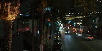 Movie still from “Sitting in Bars with Cake” (2023), directed by Trish Sie – A blurry picture of a city street at night; Medium shot, Low angle