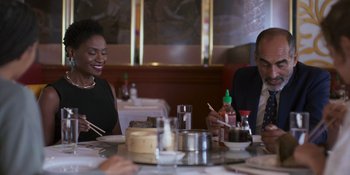 Movie still from “Sitting in Bars with Cake” (2023), directed by Trish Sie – Two people sitting at a table with chopsticks; Medium shot, Over the shoulder angle