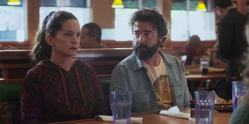Movie still from “Sitting in Bars with Cake” (2023), directed by Trish Sie – A man and a woman sitting at a table in a restaurant; Medium shot, Over the shoulder angle