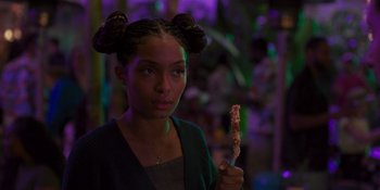 Movie still from “Sitting in Bars with Cake” (2023), directed by Trish Sie – A young girl holding a piece of pizza; Close Up shot, Over the shoulder angle