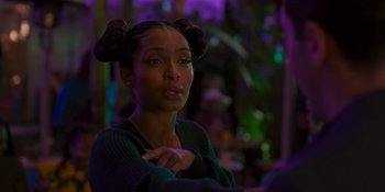 Movie still from “Sitting in Bars with Cake” (2023), directed by Trish Sie – A young woman with two pigtails sitting in a room; Close Up shot, Over the shoulder angle