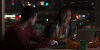 Movie still from “Sitting in Bars with Cake” (2023), directed by Trish Sie – A man and a woman sitting in front of a computer; Medium shot, Over the shoulder angle