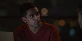 Movie still from “Sitting in Bars with Cake” (2023), directed by Trish Sie – A man in a red shirt is looking to his left; Close Up shot, Over the shoulder angle